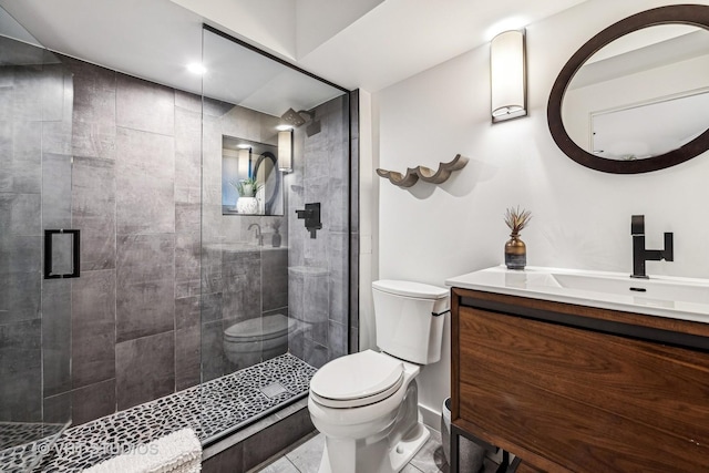 bathroom featuring vanity, toilet, a shower stall, and tile patterned floors