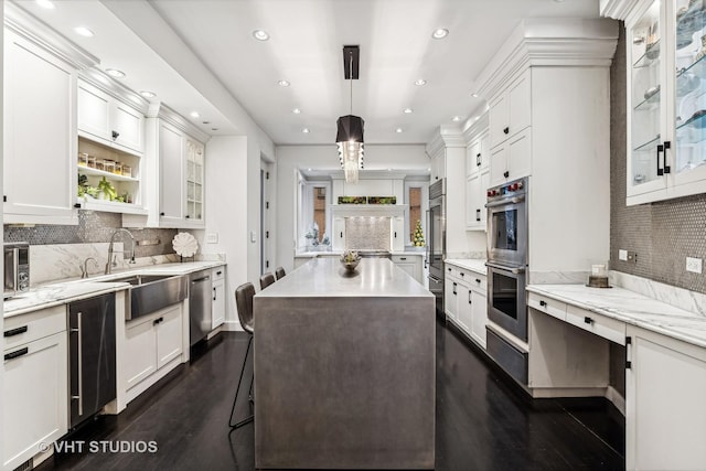 kitchen with recessed lighting, a sink, decorative backsplash, dark wood-type flooring, and stainless steel appliances