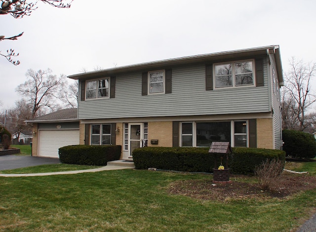 571 Dawn Cir, Grayslake, IL 60030 - colonial house with a front yard, brick siding, aphalt driveway, and a garage