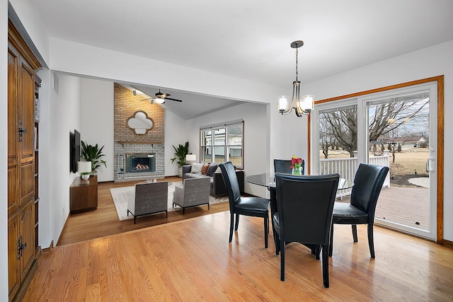 2800 Abbington Dr, New Lenox, IL 60451 - dining space with a ceiling fan, light wood-style flooring, vaulted ceiling, a fireplace, and a chandelier
