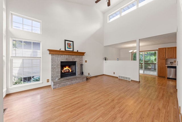726 Hawthorne Ln, Genoa, IL 60135 - unfurnished living room featuring high vaulted ceiling, ceiling fan, light wood finished floors, a fireplace, and healthy amount of natural light