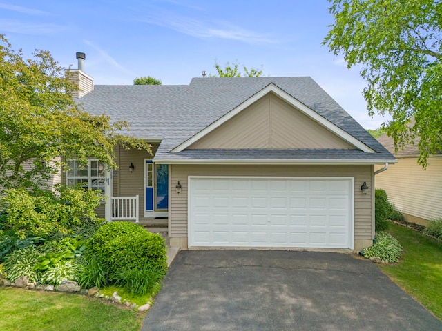 726 Hawthorne Ln, Genoa, IL 60135 - view of front facade with asphalt driveway, a chimney, a shingled roof, and a garage