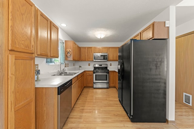 726 Hawthorne Ln, Genoa, IL 60135 - kitchen with stainless steel appliances, light wood-style flooring, light countertops, brown cabinets, and recessed lighting