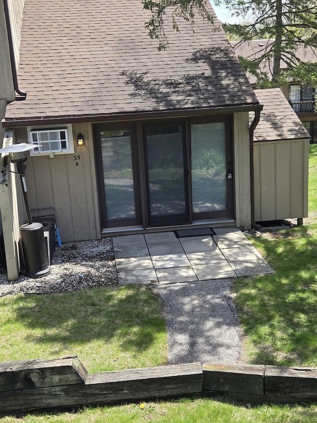 35 Montego Colony Unit 4, Fox Lake, IL 60020 - property entrance with a yard, board and batten siding, roof with shingles, and an AC wall unit