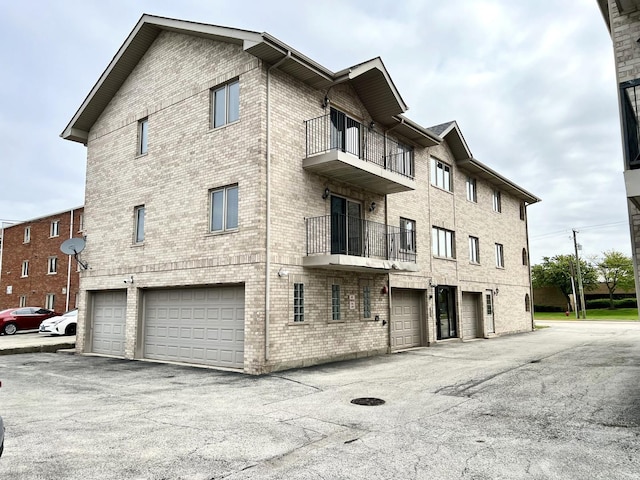 view of building exterior featuring an attached garage and asphalt driveway