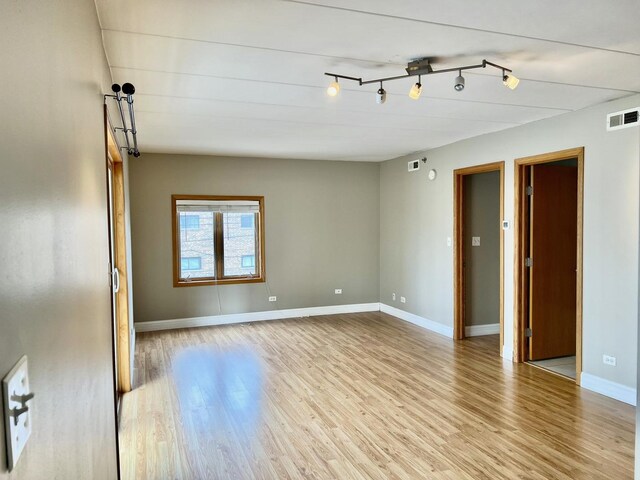 empty room with light wood finished floors and baseboards