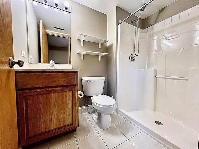 bathroom featuring tile patterned flooring, a shower, toilet, and vanity