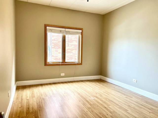empty room featuring wood finished floors and baseboards