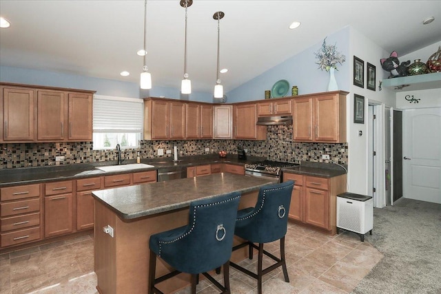 24725 W Hawthorne Dr, Round Lake, IL 60073 - kitchen featuring a sink, under cabinet range hood, stainless steel appliances, dark countertops, and a kitchen breakfast bar