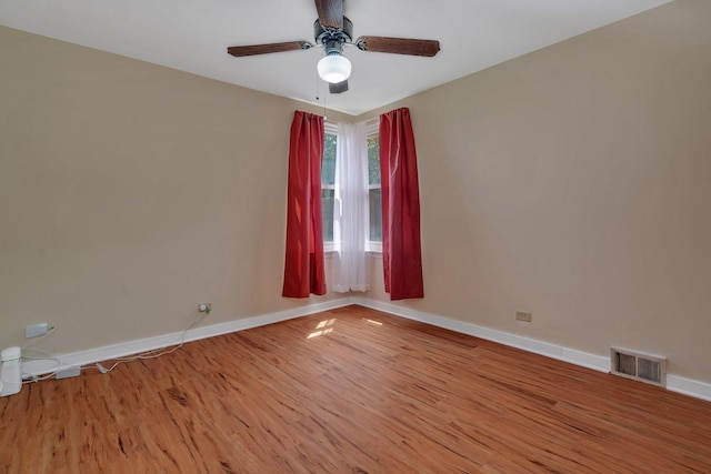 unfurnished room featuring baseboards, wood finished floors, and a ceiling fan