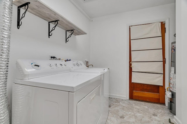 laundry area with washing machine and clothes dryer and baseboards