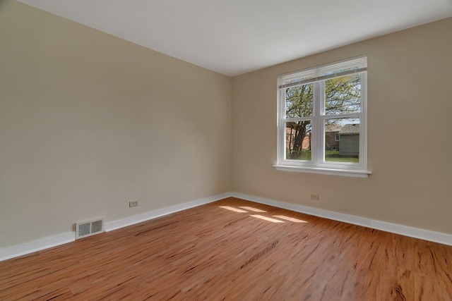 unfurnished room with baseboards and light wood-style flooring