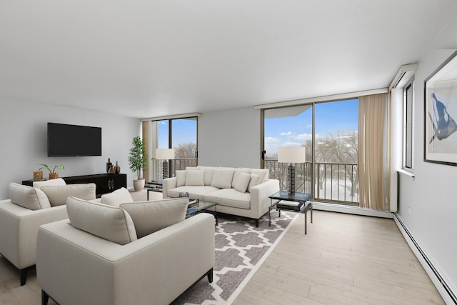 living area featuring a baseboard radiator, expansive windows, and light wood-style floors