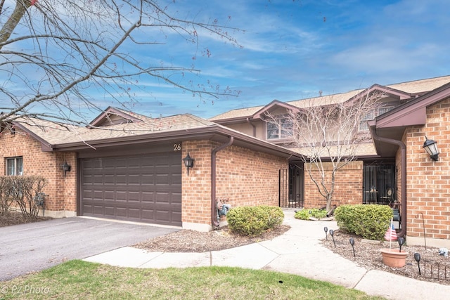 26 Prairie Dr, Westmont, IL 60559 - view of front facade with an attached garage, a shingled roof, brick siding, and driveway