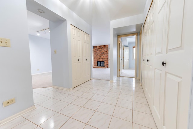 26 Prairie Dr, Westmont, IL 60559 - spare room featuring track lighting, a fireplace, light carpet, light tile patterned floors, and baseboards