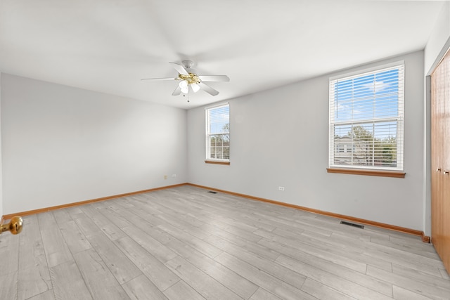 empty room featuring ceiling fan, baseboards, and light wood-style flooring