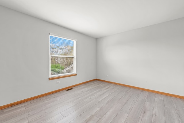 empty room with light wood-style flooring and baseboards
