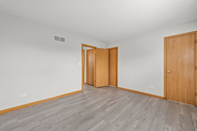 unfurnished bedroom featuring light wood finished floors and baseboards