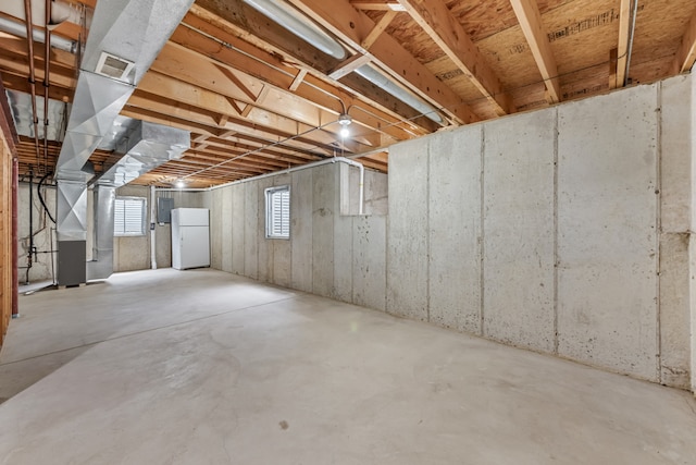 below grade area with freestanding refrigerator and heating unit
