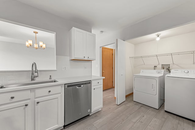 kitchen featuring dishwasher, independent washer and dryer, a sink, light wood-style floors, and a chandelier