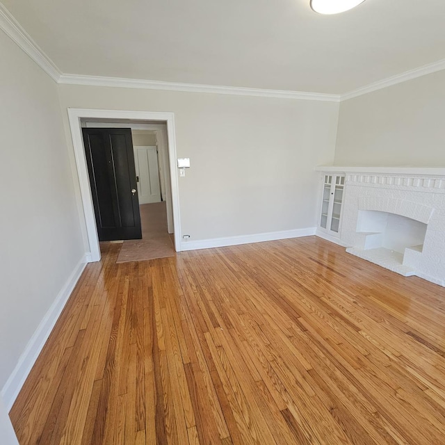 5321 W Crystal St, Chicago, IL 60651 - unfurnished living room with crown molding, a brick fireplace, baseboards, and light wood-type flooring