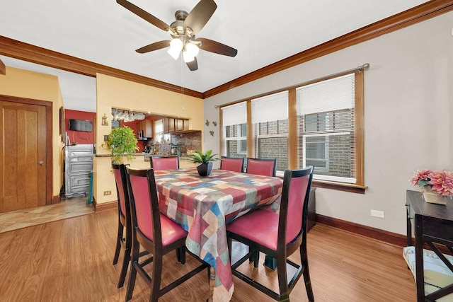 dining area with light wood finished floors, crown molding, baseboards, and a ceiling fan