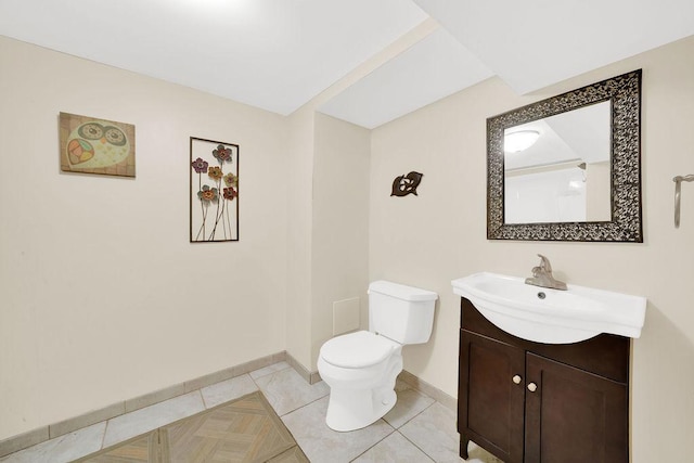 bathroom featuring toilet, baseboards, vanity, and tile patterned flooring