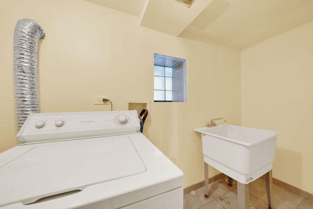 washroom featuring baseboards, washer / dryer, laundry area, and a sink
