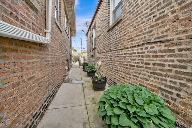 view of side of property with a patio area and brick siding