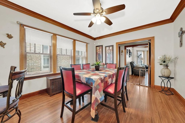 dining space with light wood finished floors, ornamental molding, baseboards, and a ceiling fan