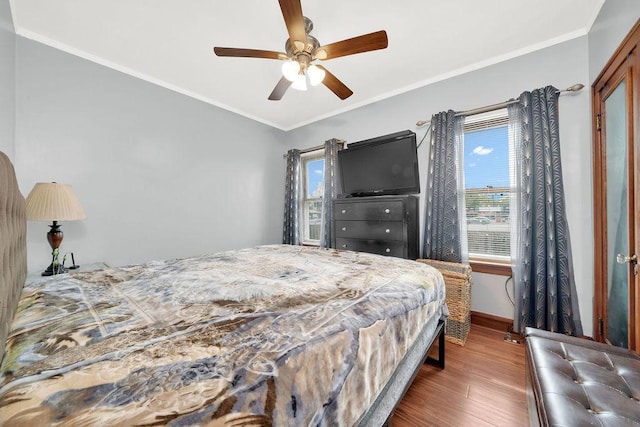 bedroom with a ceiling fan, wood finished floors, baseboards, and ornamental molding