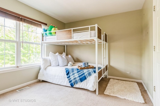 bedroom with multiple windows, baseboards, and carpet