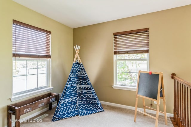 rec room with baseboards and carpet