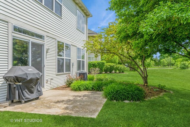 view of grassy yard featuring a patio area and central AC unit