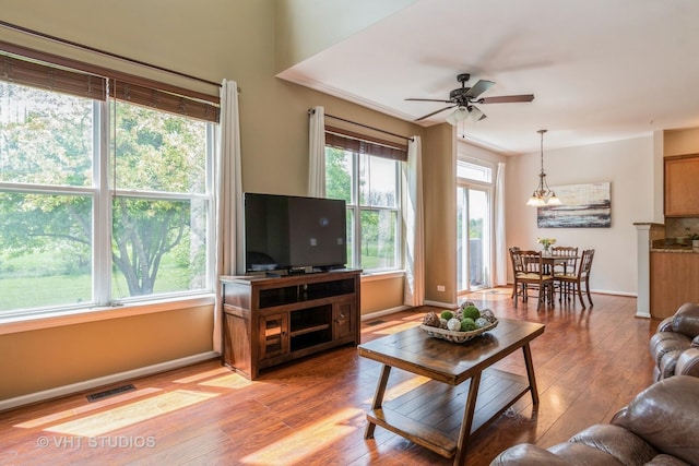 living room featuring light wood-style flooring, ceiling fan, and baseboards