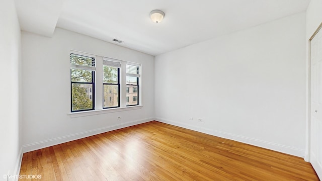 spare room featuring light wood-style floors and baseboards