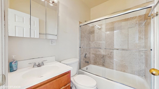 bathroom with toilet, shower / bath combination with glass door, and vanity