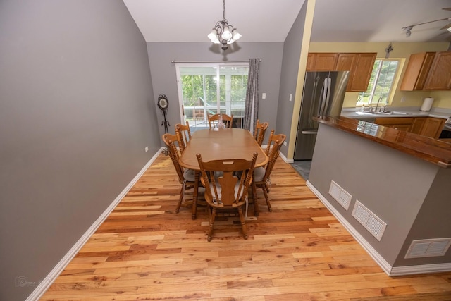 1012 Belden Way, Joliet, IL 60435 - dining space featuring light wood-type flooring, healthy amount of natural light, a chandelier, baseboards, and vaulted ceiling