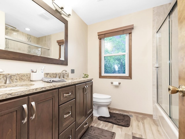 848 Braintree Ln, Bartlett, IL 60103 - full bathroom featuring double vanity, toilet, enclosed tub / shower combo, wood finished floors, and baseboards