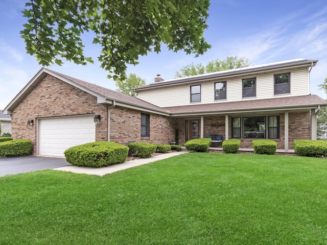 848 Braintree Ln, Bartlett, IL 60103 - view of front of home with a chimney, a garage, a front lawn, covered porch, and brick siding