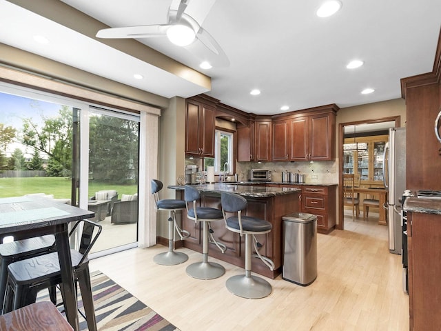 848 Braintree Ln, Bartlett, IL 60103 - kitchen with light wood-style flooring, backsplash, a sink, a kitchen breakfast bar, and plenty of natural light