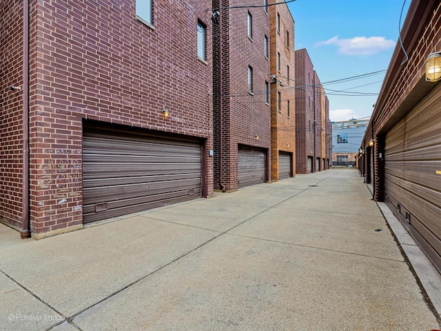 exterior space featuring concrete driveway and brick siding
