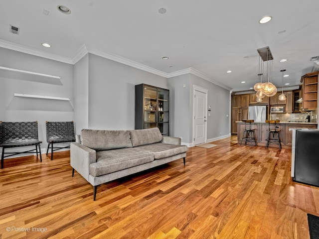 living area featuring light wood finished floors, crown molding, baseboards, and recessed lighting