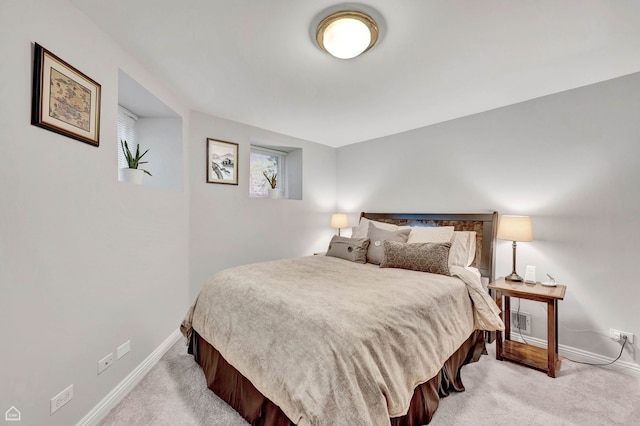 bedroom with light carpet and baseboards