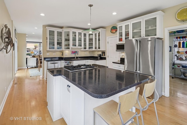 6927 N Oleander Ave, Chicago, IL 60631 - kitchen with appliances with stainless steel finishes, white cabinets, light wood-style floors, baseboards, and a center island