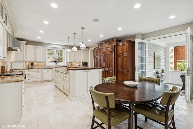 3324 Lakeside Ave, Northbrook, IL 60062 - kitchen with under cabinet range hood, plenty of natural light, an island with sink, recessed lighting, and stone tile floors