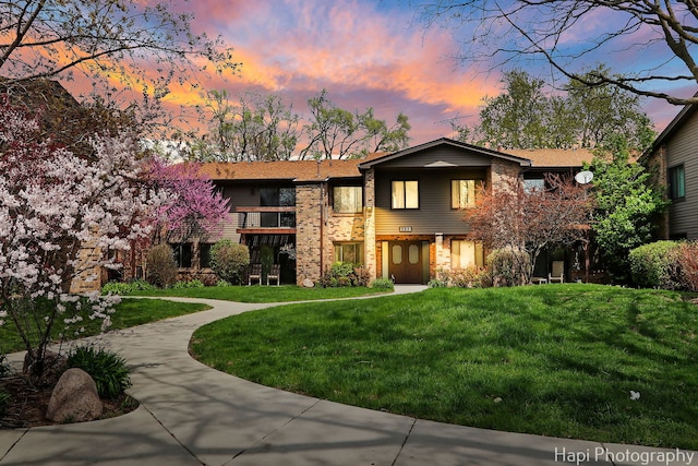 1132 E Randville Dr Unit 2E, Palatine, IL 60074 - back of house at dusk with a balcony, brick siding, and a lawn