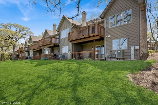 rear view of property featuring a lawn, a wooden deck, and central air condition unit