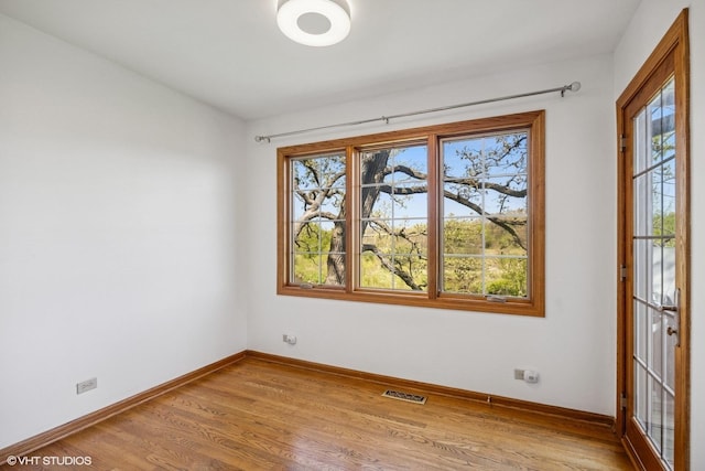 unfurnished room featuring light wood finished floors and baseboards