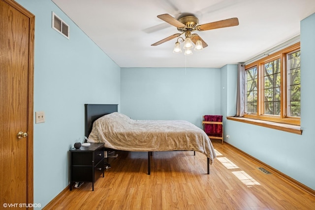 bedroom featuring light wood finished floors, baseboards, and a ceiling fan